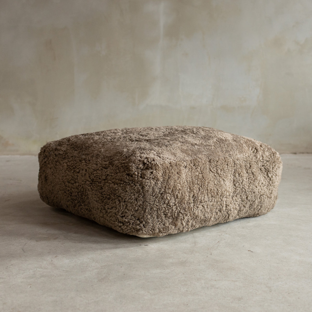 Coussin de sol peau de mouton bouclée sahara 65x65x20 cm posé au sol, effet teddy