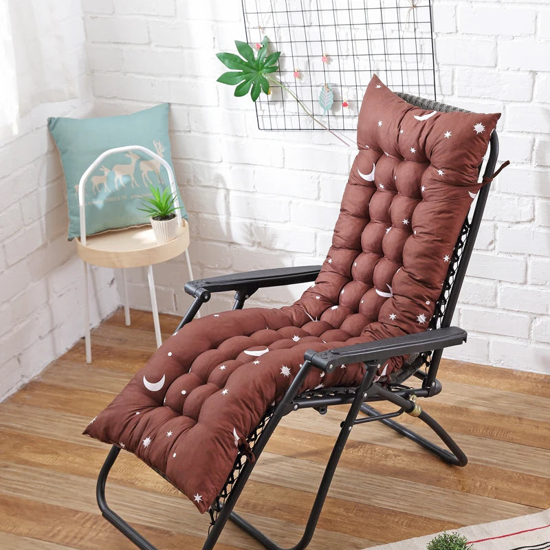 Coussin bain de soleil imperméable et marron sur une chaise sur un parquet avec un mur blanc en briques en fond